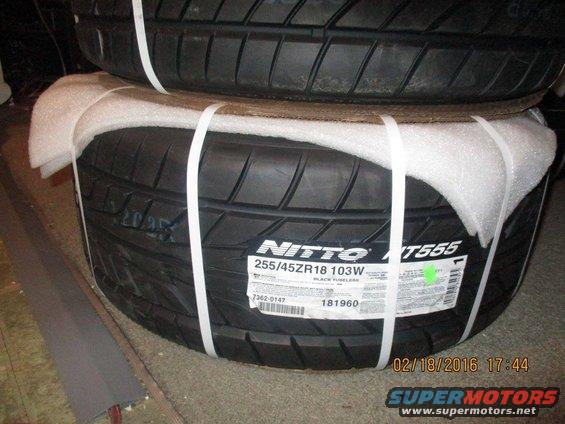Two stacked Nitto NT555 tires, one with a label showing size 255/45ZR18 103W