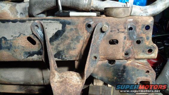 Rusted metal frame with bolted bracket and hose clamp. Text '3IN' is marked on the frame