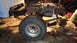 1985 Ford Bronco - The frame and suspension of a truck are visible, with a large tire in the foreground.