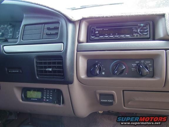 Tan dashboard interior with Kenwood stereo, climate controls, and a car phone