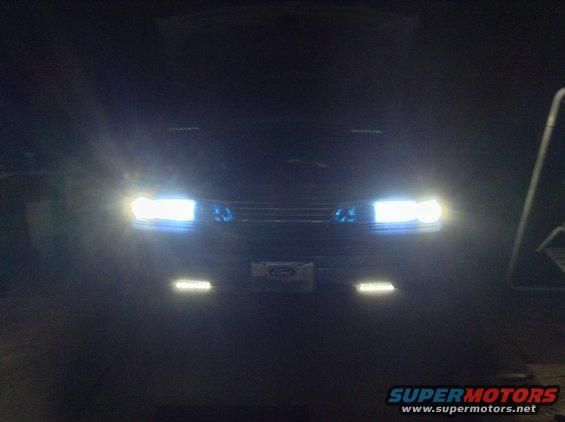 Front view of a 1994 Ford Crown Victoria with headlights on