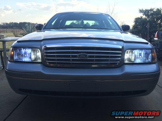 Silver Ford Crown Victoria front view, chrome grille, blue-tinted headlights