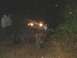 1978 Ford Bronco - A group of people stand near a heavily modified off-road vehicle on a muddy path at night.