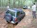 1978 Ford Bronco - A Toyota 4Runner navigates a challenging off-road obstacle, with another vehicle and onlookers present in the wooded terrain.