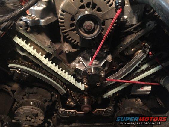 New guides, tensioner and water pump, installed, was waiting for tensioner to arrive so bungee kept tension on the chain to prevent the chain from slipping.