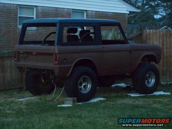 Brown 1972 Ford Bronco with black hardtop, lifted on large tires