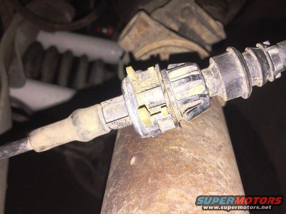 Spark plug with ceramic insulator and metal electrode, showing some wear