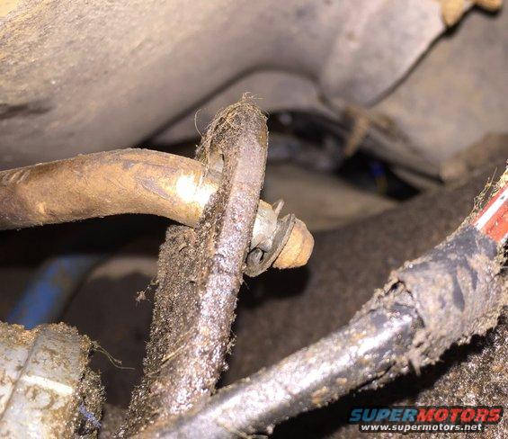 Close-up of dirty shifter linkage parts with a bolt and washer
