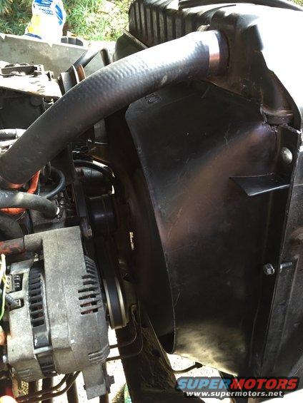 Engine bay showing alternator, fan shroud, and radiator hose