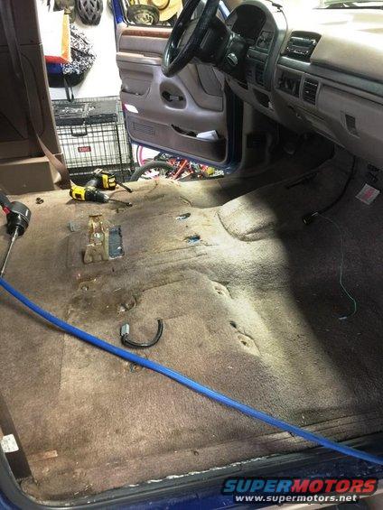 Interior of a 1996 Ford Bronco with carpet removed, showing floor and dashboard