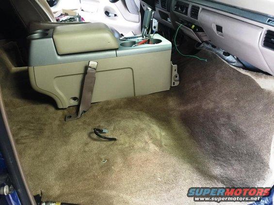 Vehicle interior with center console removed and carpet exposed