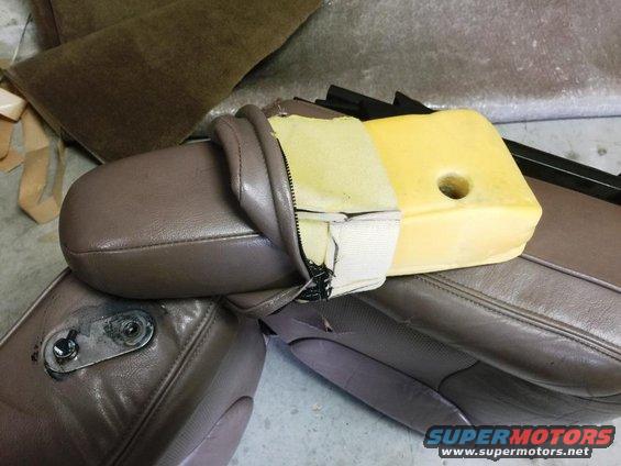 close-up of car seat cushion with exposed foam and torn upholstery