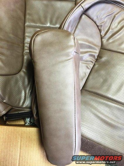 tan leather car seat armrest and perforated seat fabric