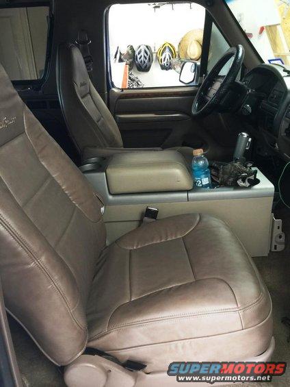 Tan leather seats and center console of a 1996 Ford Bronco, with a water bottle and other items on the console