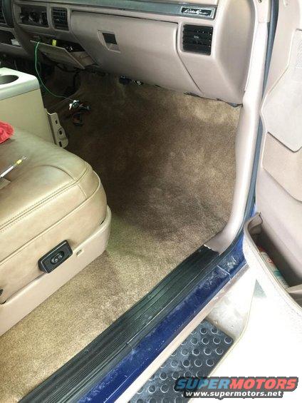 Interior view of a 1996 Ford Bronco showing the tan carpet, dashboard, and driver's seat