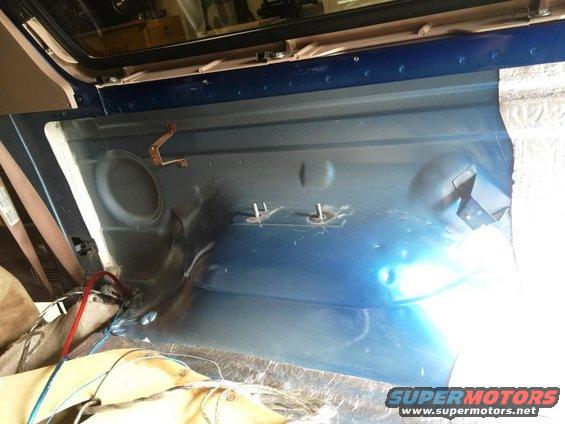 Blue interior cargo area with exposed metal, speaker cutout, and mounting brackets