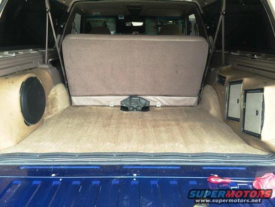 1996 Ford Bronco interior cargo area with custom subwoofer box on left and speaker boxes on right