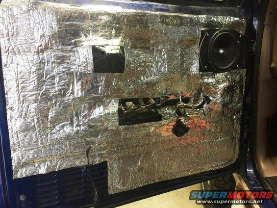 Car door panel removed, showing sound deadening material and a speaker installed