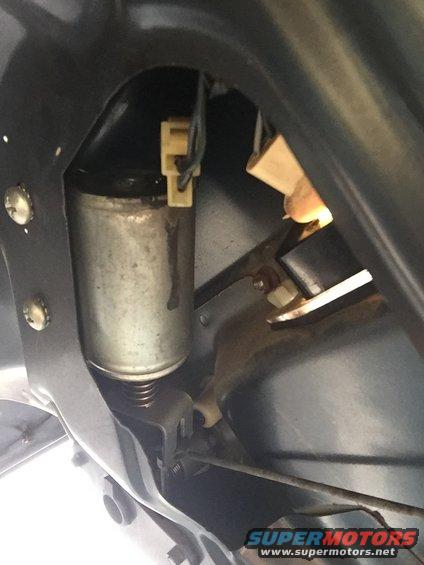 Close-up of a vehicle door lock actuator motor with wiring connectors