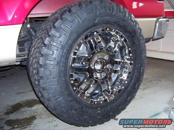 Red and tan truck wheel with chrome rim and aggressive tire tread, close-up