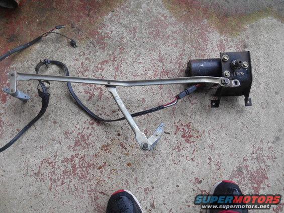 Windshield wiper motor assembly with linkage and wiring on concrete