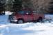 1988 Chevrolet Silverado 2500 - A red 1988 Chevrolet Silverado 2500 pickup truck is partially submerged in snow, with its front wheels turned.
