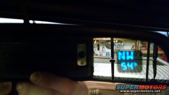 Interior rearview mirror showing a digital display with 'NW' and '54'