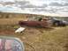 1971 Ford Ranchero - Abandoned 1971 Ford Ranchero sits in a field with other vehicles in the background.