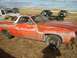 1971 Ford Ranchero - This weathered orange 1970 Ford Ranchero sits in a dusty lot with other vehicles.