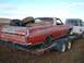 1971 Ford Ranchero - A red Ford Ranchero, likely a 1970 model, is being transported on a trailer behind a pickup truck.
