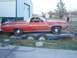 1971 Ford Ranchero - A red Ford Ranchero, likely from the early 1970s, is parked on a trailer in front of a large building.