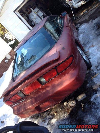 Red 1995 Ford Probe coupe with a rear spoiler, parked in snow