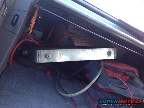 Aftermarket electronic box with red and green wires mounted in a vehicle's interior