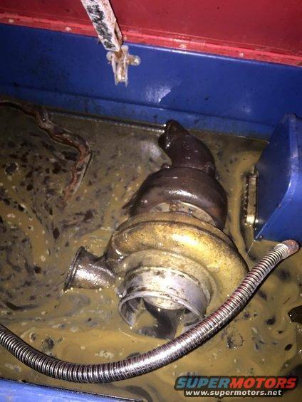 Turbocharger submerged in murky fluid