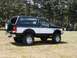 1994 Ford Bronco - This two-tone dark green and white 1994 Ford Bronco is shown from a three-quarter front view with a spare tire mounted on the rear door.