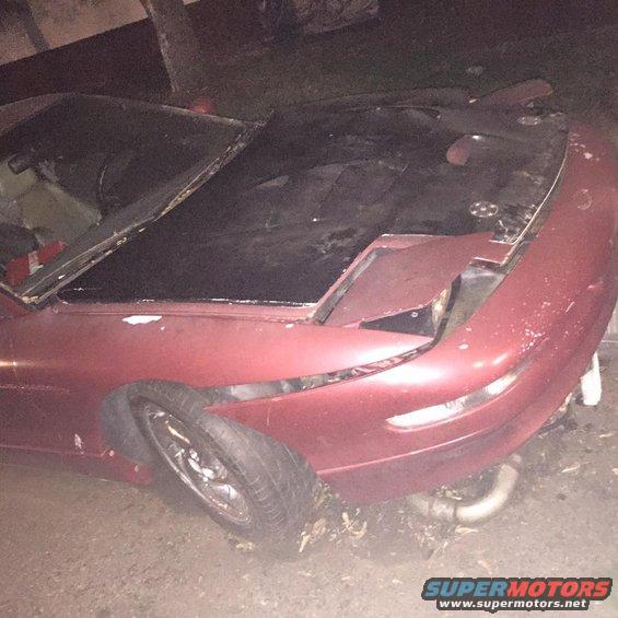 Red 1995 Ford Probe with damaged front end and hood