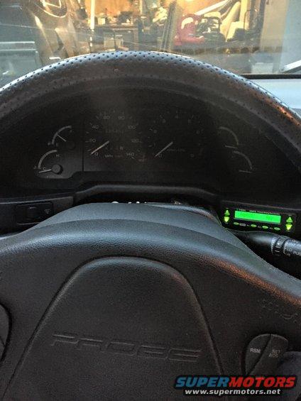 Interior view of a car with 'PROBE' on the steering wheel and a green digital display