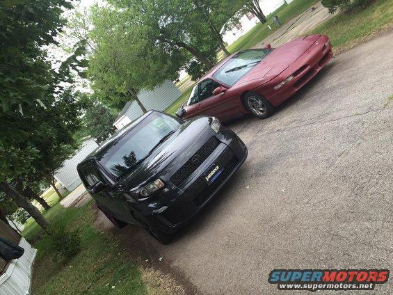 Red 1995 Ford Probe and black Scion xB parked on a driveway
