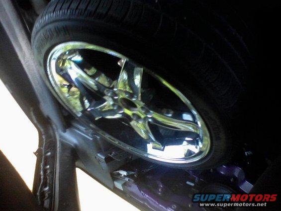 Spare tire and chrome wheel inside a vehicle's wheel well