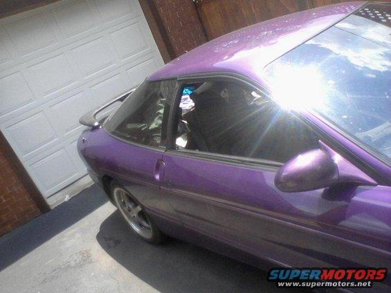 Purple 1995 Ford Probe parked in front of a garage door