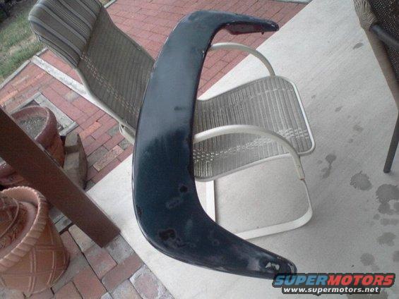 Dark blue car spoiler resting on outdoor chairs