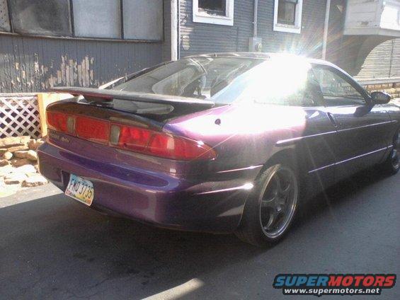 Purple 1995 Ford Probe with a spoiler, parked outside a house