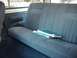 1993 Ford Bronco - The interior of a vehicle shows a blue upholstered back seat with two books resting on it.