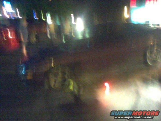 Blurry image of a car at night with streetlights