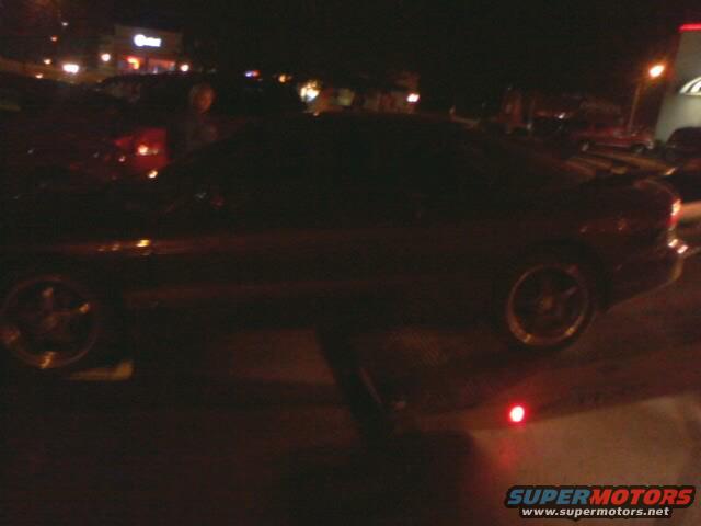 Dark coupe side view at night, with visible Supermotors logo