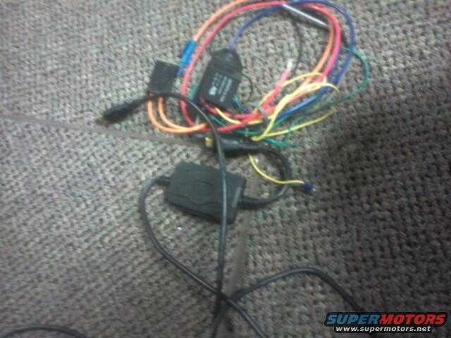 Wiring harness with black boxes and colorful wires on carpet