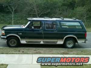 Dark green Ford Bronco SUV with wood paneling on the lower body, seen from the side