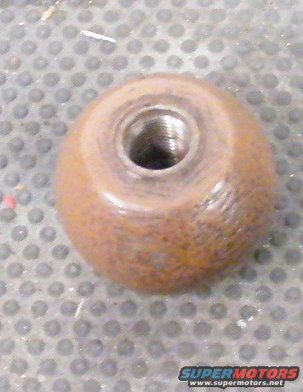 Rusted metal knob with internal screw threads on a textured surface