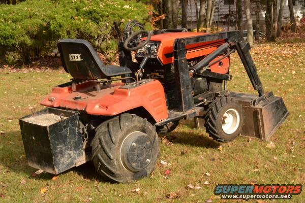 Orange tractor with a black front loader and a black seat with "KEES" visible