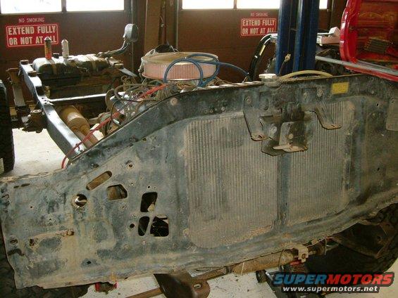 Vehicle chassis and engine assembly, partially disassembled, with radiator visible